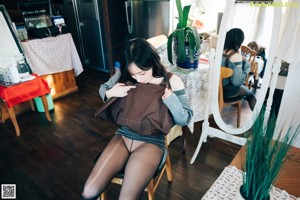 A woman in black pantyhose and white sneakers posing for the camera.