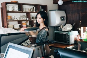 A woman sitting on a chair in a kitchen.