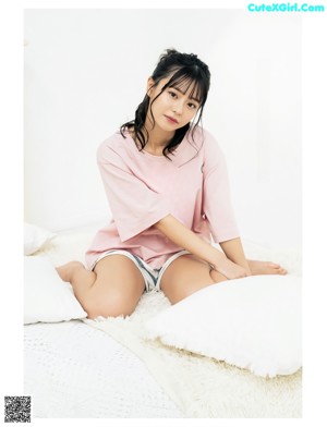 A woman in a pink shirt is posing for a picture.