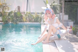 A woman in a bunny costume floating in a pool.
