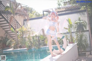 A woman in a bunny costume sitting by a pool.