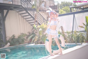 A woman in a bunny costume floating in a pool.