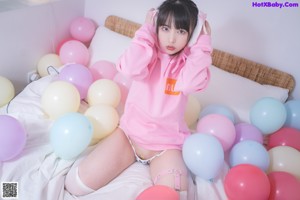 a woman in a pink hoodie and white stockings posing for a picture