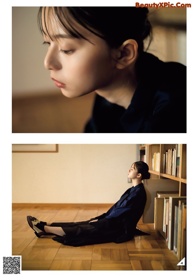 A woman sitting on the floor in front of a bookshelf.