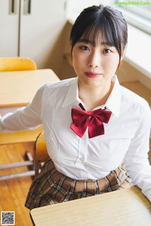 A woman in a white shirt and panties sitting on a desk.