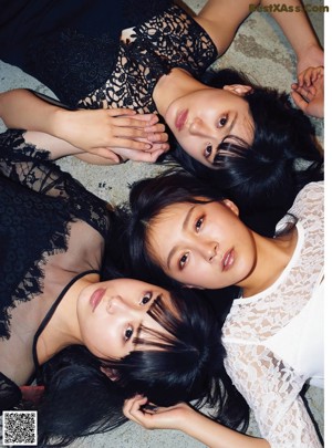 A group of young women eating a strawberry.