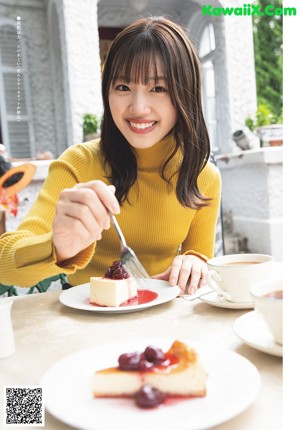 A woman holding a waffle in front of her face.