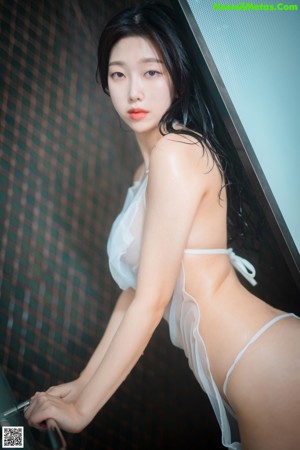 A woman in a white lingerie posing for the camera.