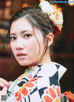 A woman in a kimono standing in front of a building.