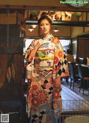 A woman in a kimono standing in front of a building.