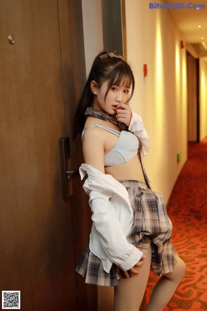 A woman in a school uniform is posing for the camera.