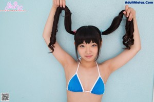 A woman in a blue and white bikini posing for a picture.