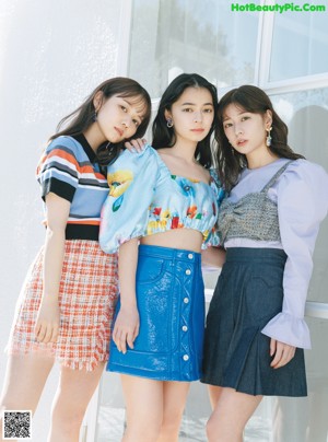 A group of three young women standing next to each other.