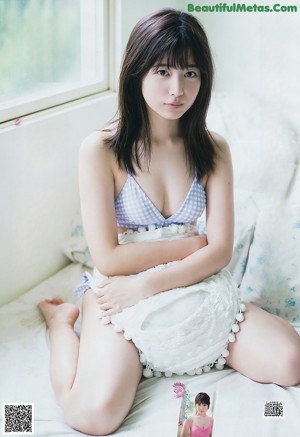 A woman in a bikini laying on a couch.
